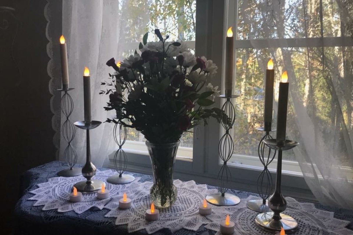 Pappilan alttarilla on kukkia ja kynttilöitä.