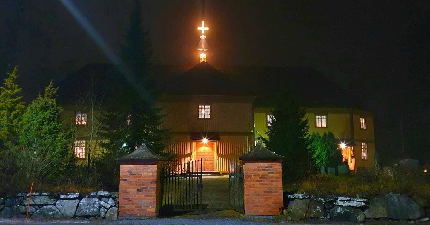 Vesilahden kirkko valaistuna Rautialantieltä kuvattuna. Kultainen risti loistaa valaistuna katolla.