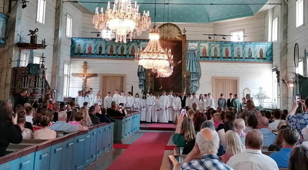 Rippikoululaiset kofirmaatiotilaisuudessa alttarin edessä.